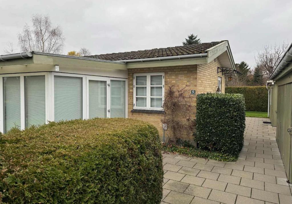 een klein huis met een heg ervoor bij Summerhouse in Liseleje in Liseleje