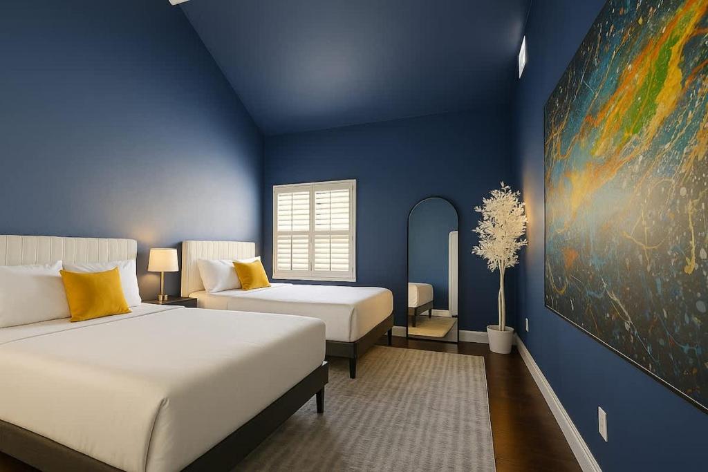 une chambre avec deux lits et un tableau au mur dans l'établissement Huge Ceilings Pool Piano ART, à Dallas