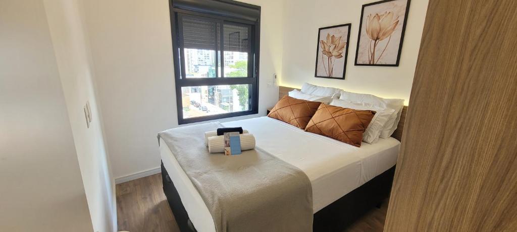 a bedroom with a bed with a pillow on it at MOEMA54 - Studio novo e completo na melhor localização de Moema, ao lado do Shopping Ibirapuera in Sao Paulo