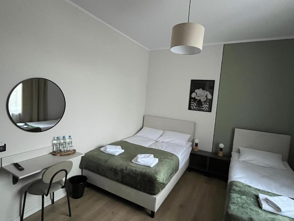 Un dormitorio con una cama, un escritorio y un espejo. en Wilczy Sen, en Ciechanów