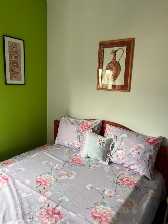 a bed with a purple comforter with flowers on it at Fenix Mostar in Mostar