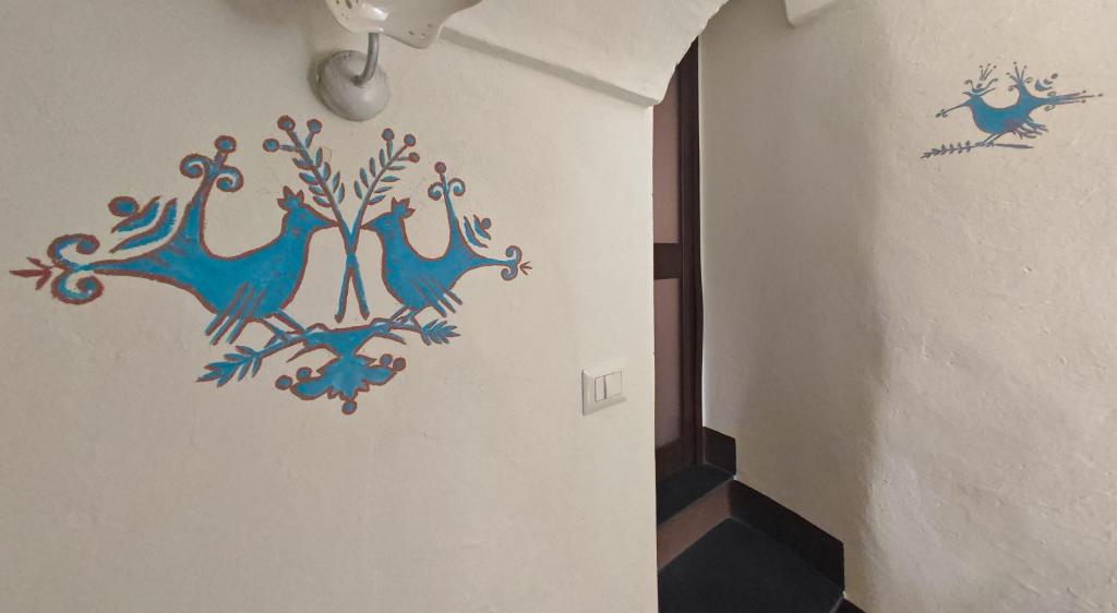 een gang met een schilderij van blauwe vogels aan de muur bij Casa Di Nonna in Cuglieri
