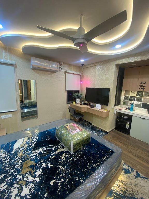 ein Wohnzimmer mit einem Deckenventilator und einem Tisch in der Unterkunft SAJ motel 02 in Belgaum