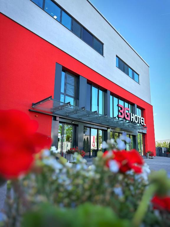 a red and white building with flowers in front of it at 3G Hotel in Fulda