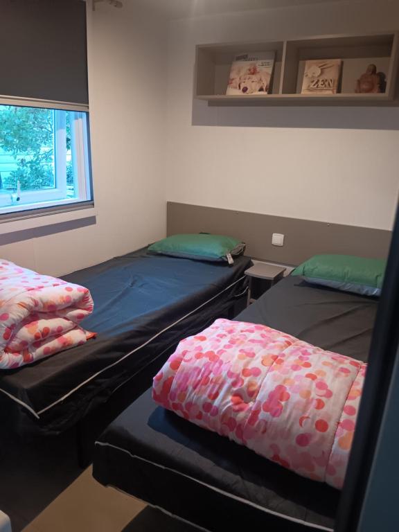 En eller flere senge i et værelse på Mobilhome a la deco zen camping sur soulac