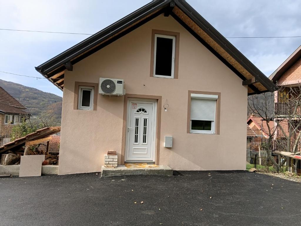 een klein huis met een deur bij Apartman,,Petko,, in Bajina Bašta