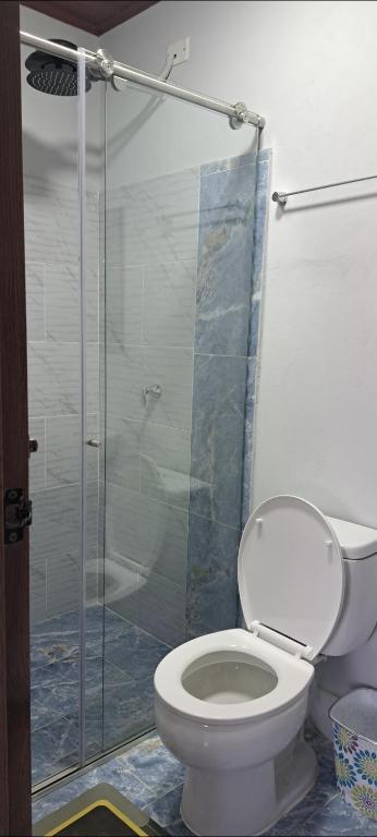 a bathroom with a toilet and a glass shower at Mirador del Molino in Fusagasuga