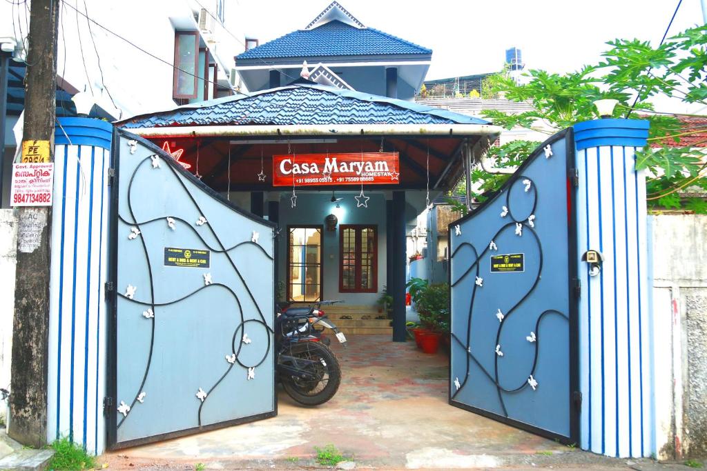 a blue building with a motorcycle parked in front of it at Casa maryam in Fort Kochi