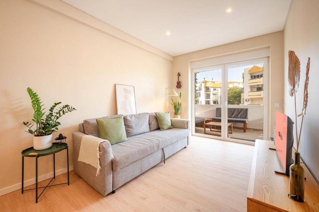 a living room with a couch and a table at GuestReady-Charming Coastal Getaway in Almada