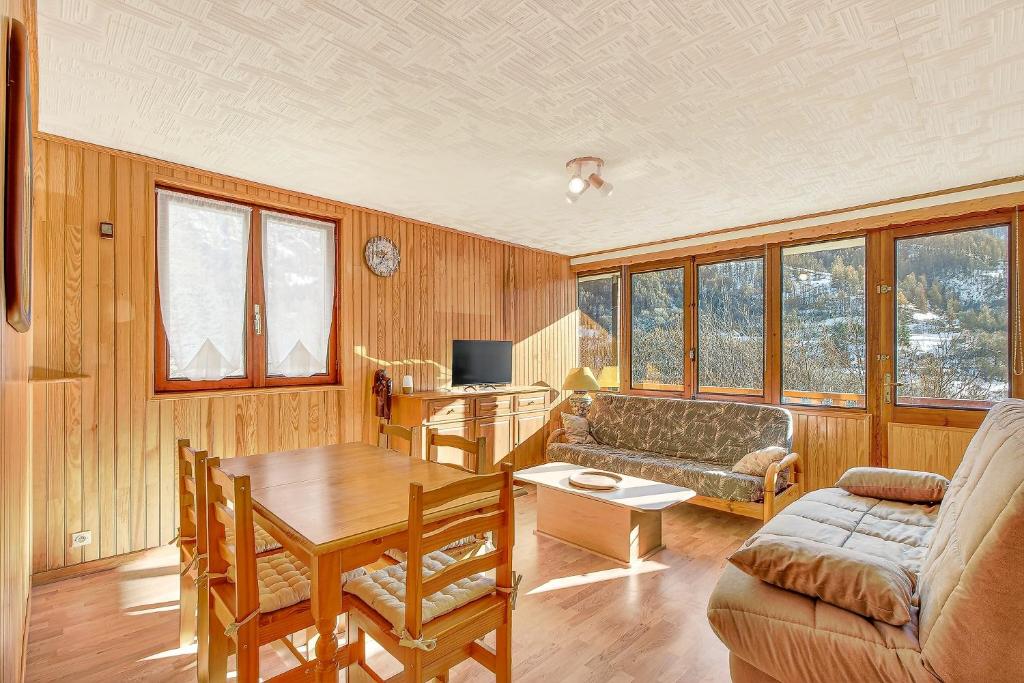 una sala de estar con un sofá y una mesa en Orciéres Village, en Orcières