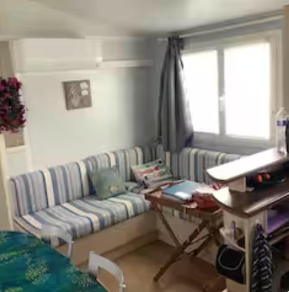 a living room with a couch and a table at L'Aurore - Mobil-home climatisé - Piscine in La Bernerie-en-Retz