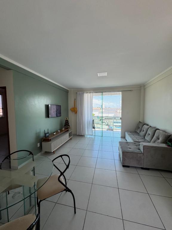 un soggiorno con un divano e un tavolo di vetro di Apartamento com duas suítes! a Macapá