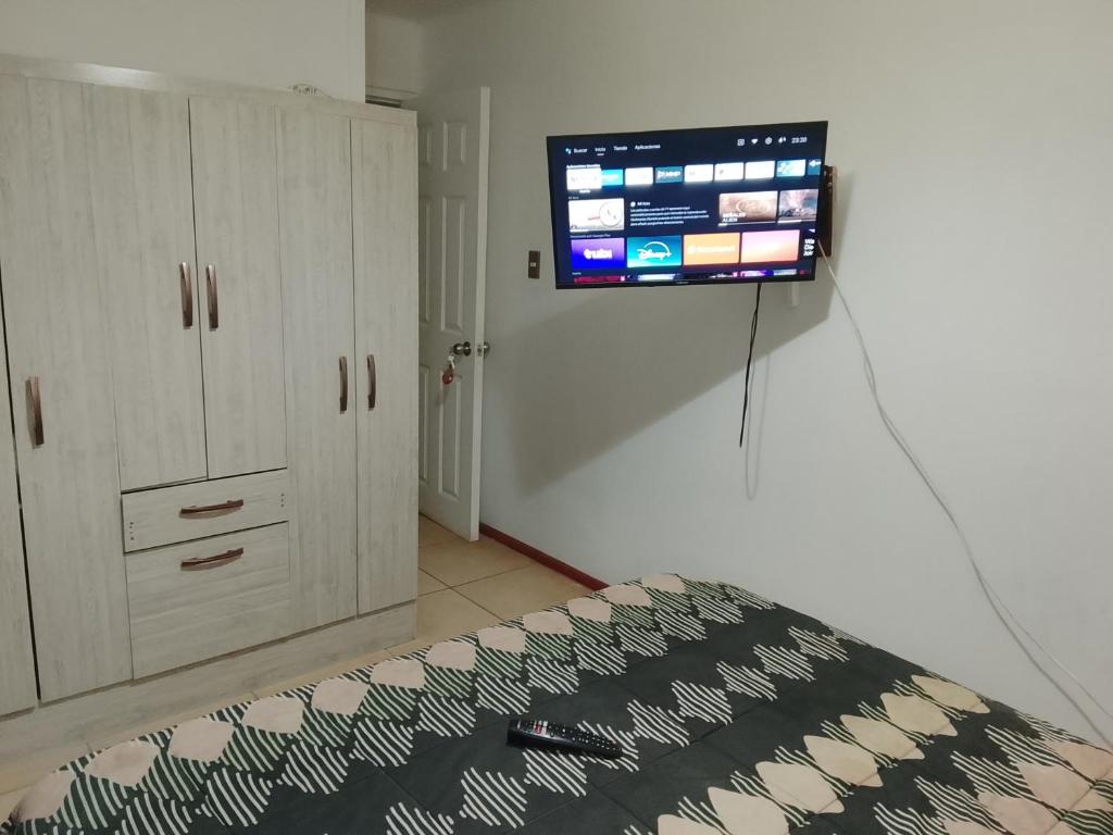 een flatscreen-tv aan een muur in een slaapkamer bij Refugio Alfalfares in La Serena