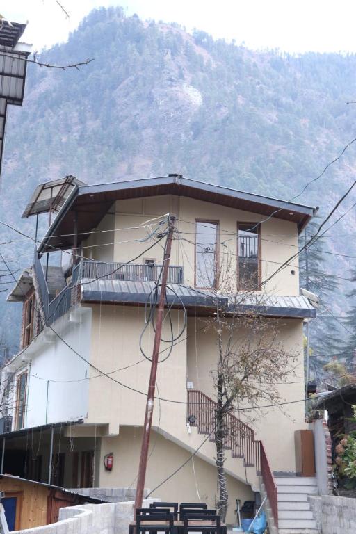 a building with a balcony and a mountain in the background at Blest Inn Kasol in Kasol