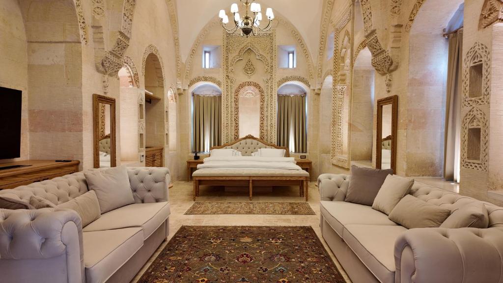 a living room with couches and a bed in a building at Shamas Hotel in Midyat