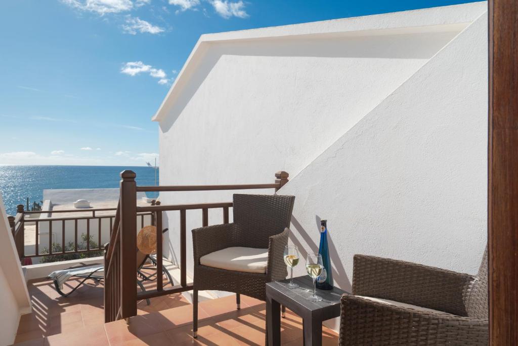 a balcony with chairs and a table and the ocean at Lanzahost Casa Campagnolo in Playa Honda