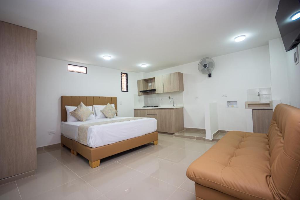 um quarto com uma cama, um sofá e uma cozinha em Apartahotel Ces em Medellín