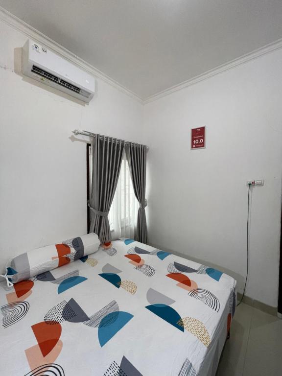 ein Schlafzimmer mit einem Bett mit einer bunten Bettdecke in der Unterkunft Cozy Homes BnB in Prampuan
