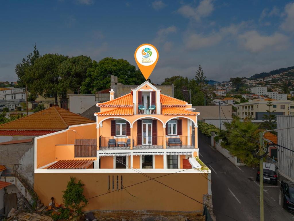 a building with an orange roof with a sign on it at Casa NOLA by Susys Holidays in Funchal
