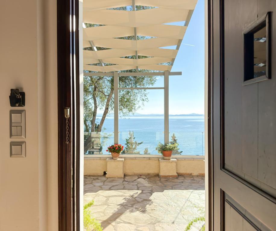 a door leading to a patio with a view of the ocean at Villa Kalami Look Out in Kalami