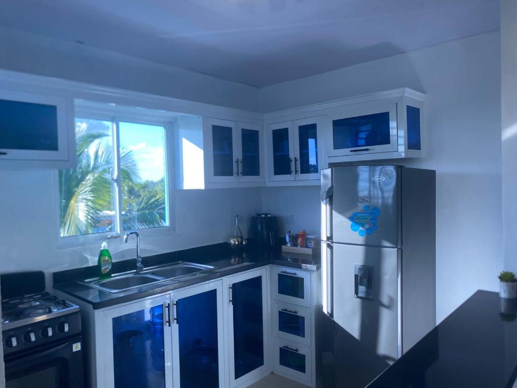 ColoradoにあるMi Rinconcitoの白いキャビネットと冷蔵庫のあるキッチン