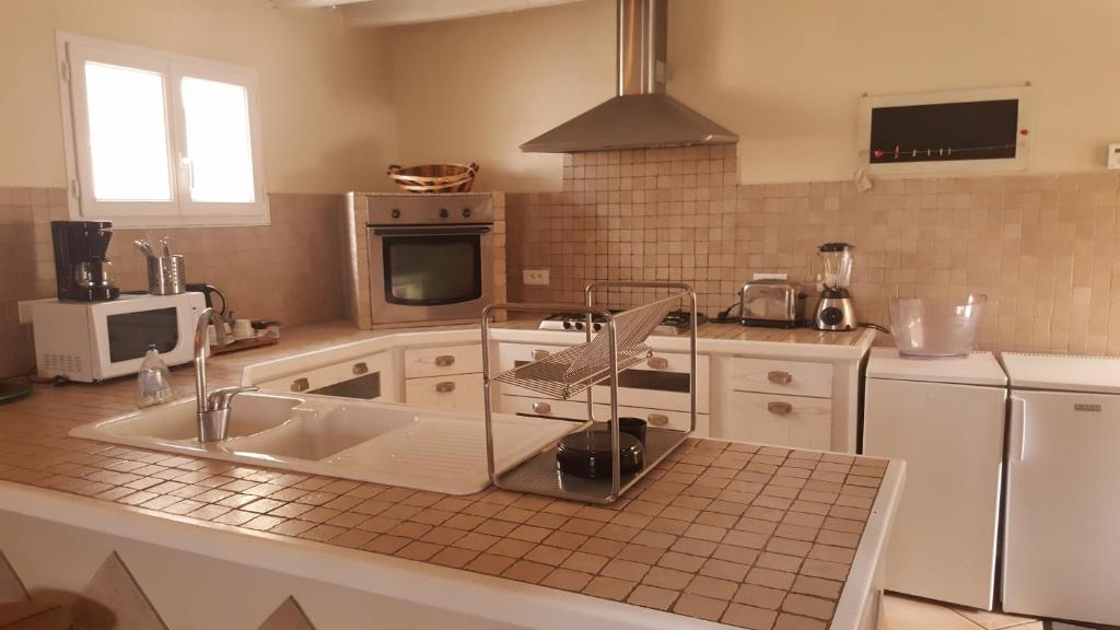 eine Küche mit einer Spüle und einer Mikrowelle in der Unterkunft Cafe de Paris in Capdenac-Gare