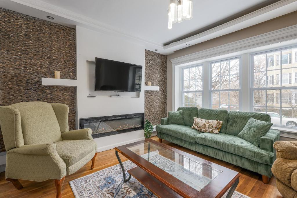 a living room with two green couches and a fireplace at Fairmont Rooms in Worcester