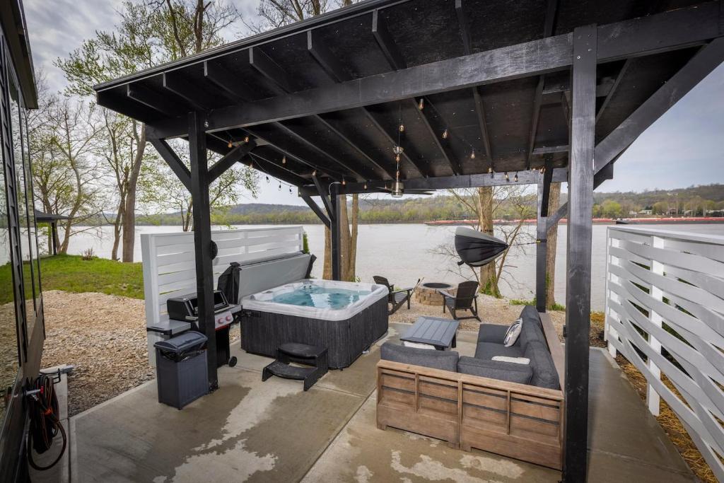 a gazebo with a hot tub and a table at Black Tie Affair - Eloquent Riverfront Experience in New Richmond
