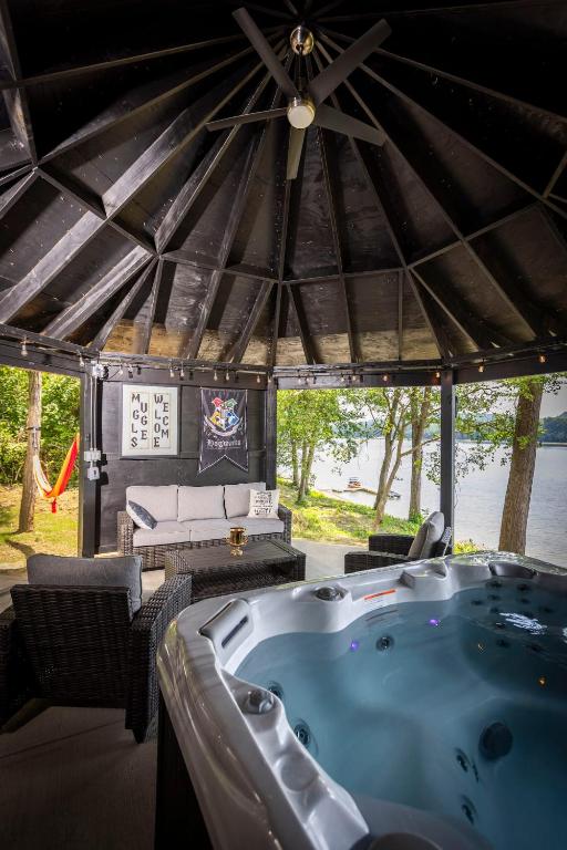 a jacuzzi tub in a pavilion with a table and chairs at Hagrid's Hut - Harry Potter Riverfront Experience in New Richmond