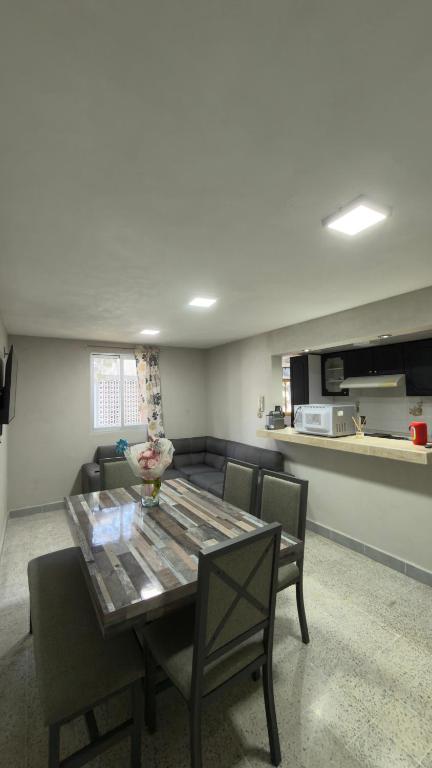 Un comedor con mesa y sillas y una cocina. en Departamento cerca de Polanco Nueva Embajada USA y el Hospital Militar, en Ciudad de México