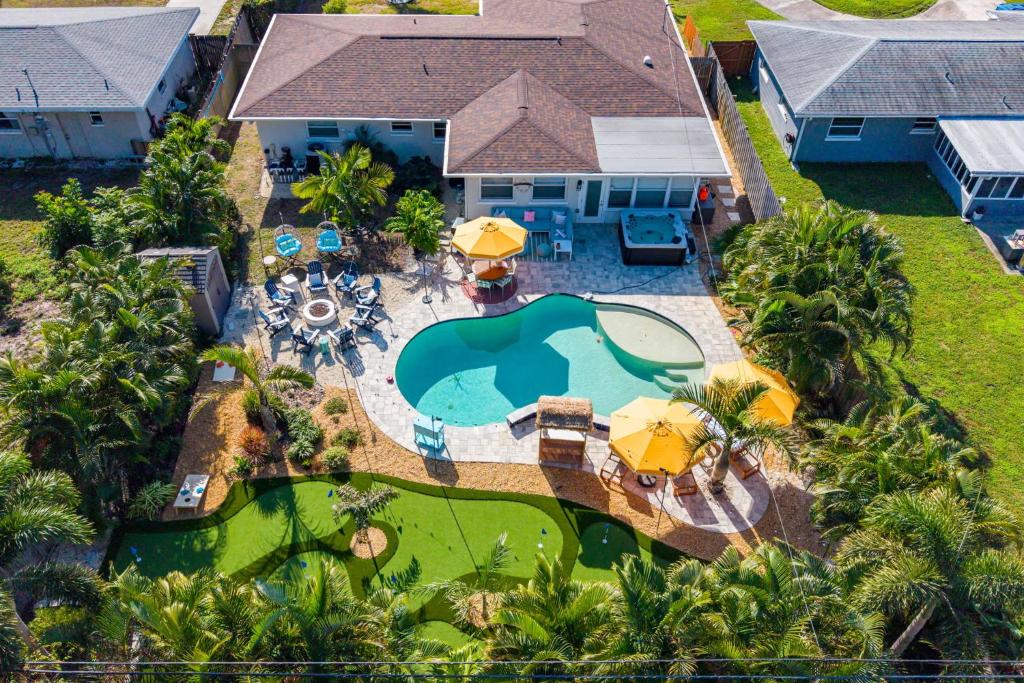 an aerial view of a house with a swimming pool and umbrellas at Resort Style Backyard Pool Hot Tub Games in Seminole