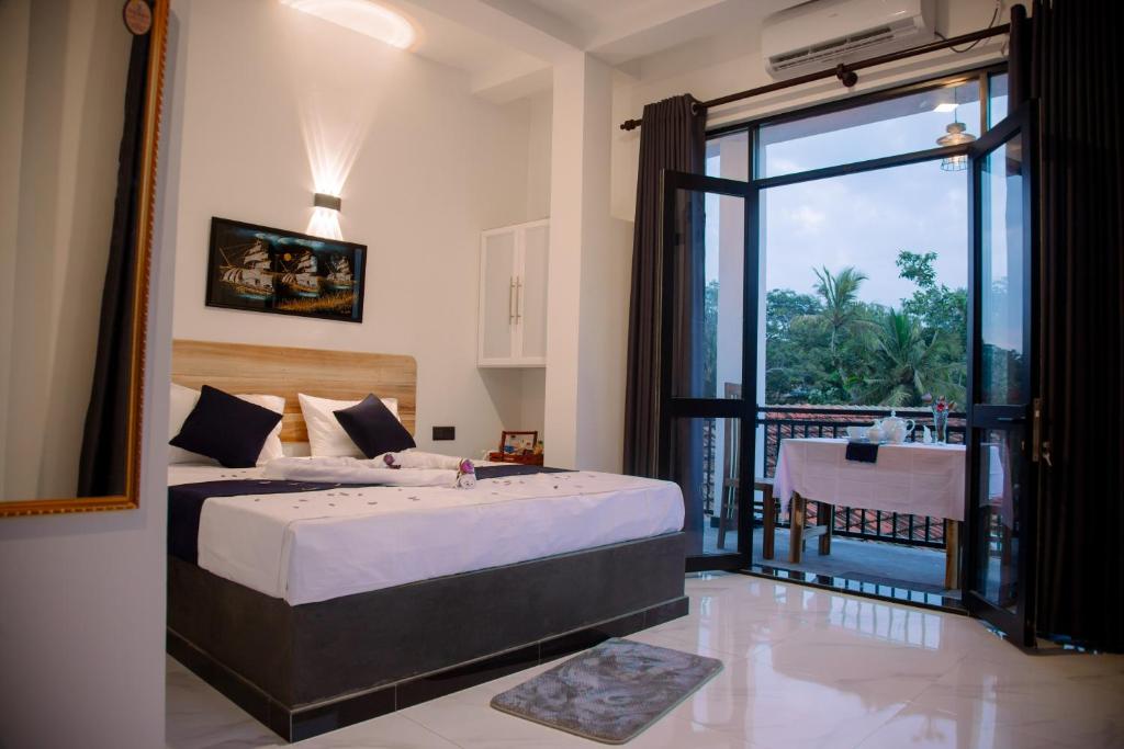 een slaapkamer met een groot bed en een balkon bij Seaside Serenity Resort in Hiriketiya