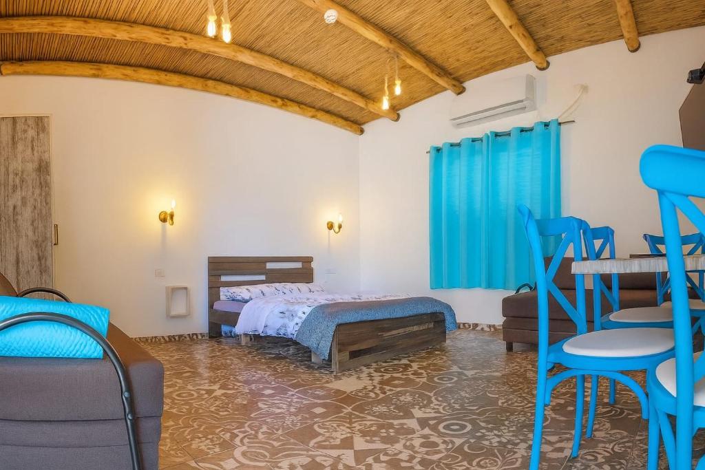 Un dormitorio con una cama y una mesa y sillas. en צימר old school, en Ein Kinya