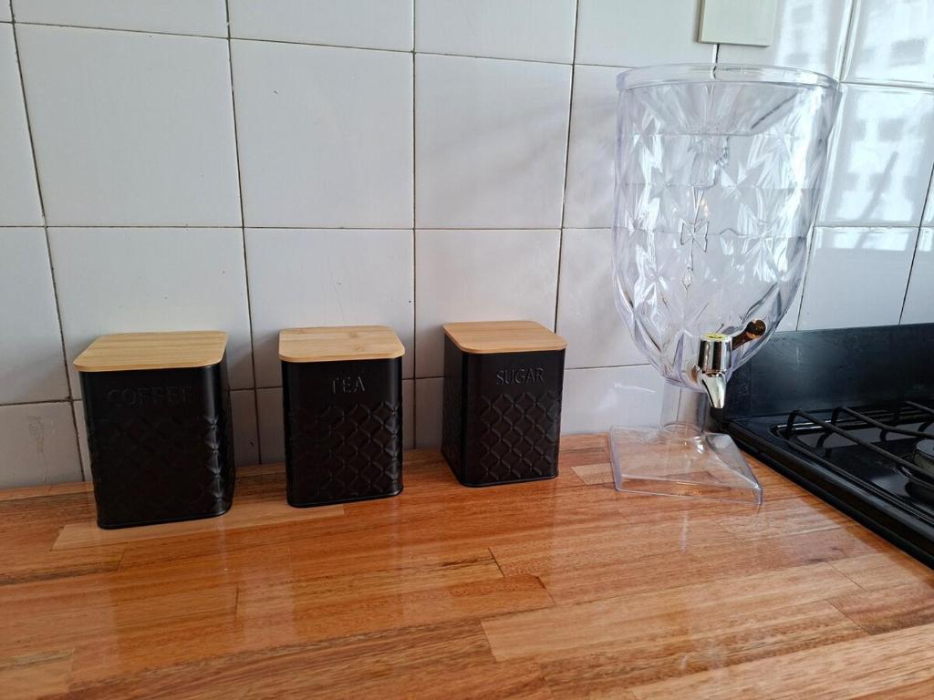 een keuken met drie vuilnisbakken naast een vaas bij kirahome in Buenos Aires