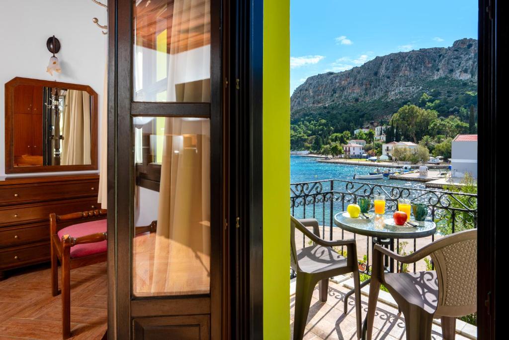 a balcony with a table and a view of the water at Mandraki Paradise in Meyisti