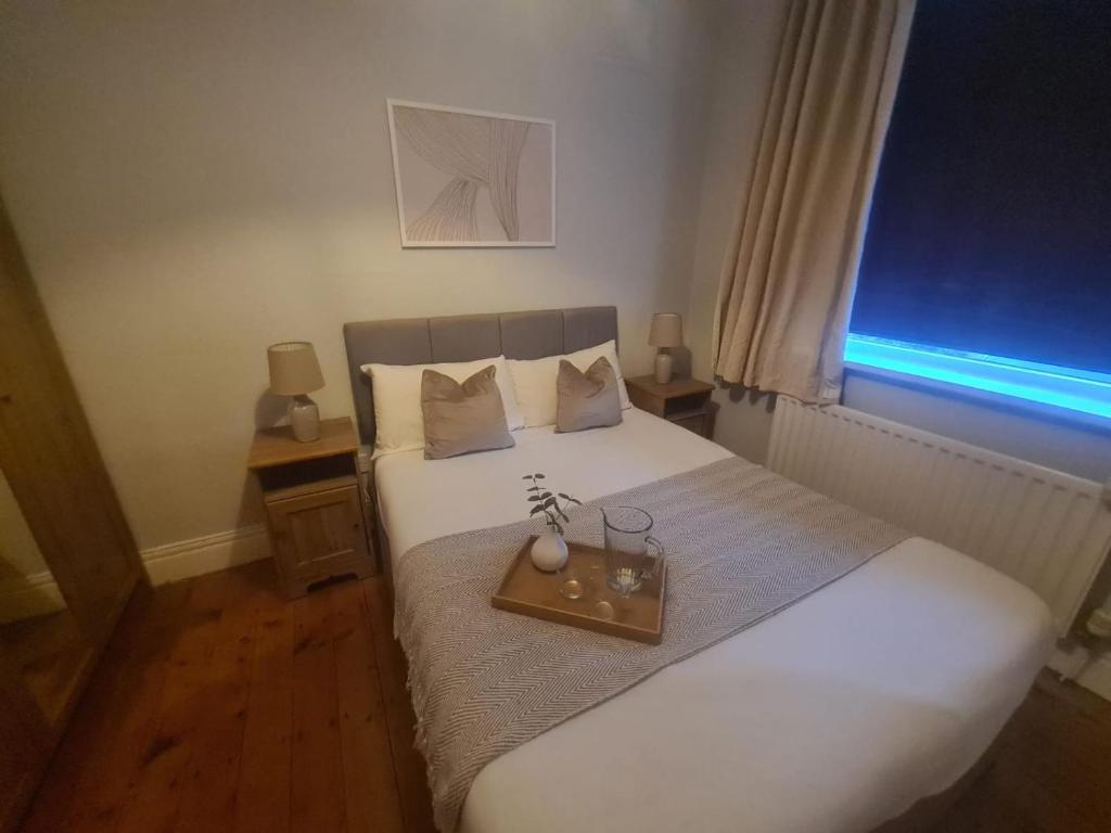 ein Schlafzimmer mit einem weißen Bett und einem Tablett darauf in der Unterkunft City North Apartment in Longbenton