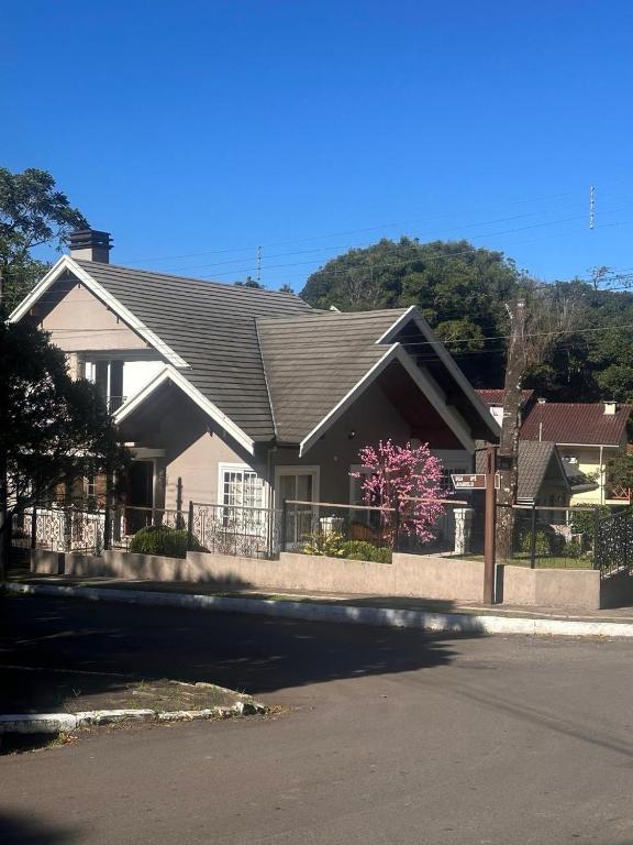 a house with a fence in front of it at Suite Ipê in Gramado