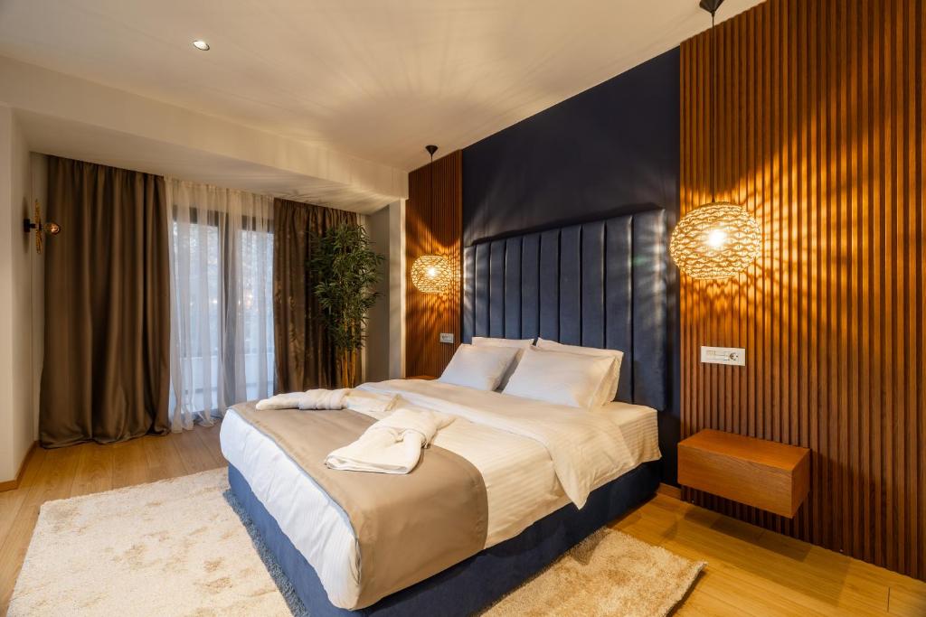 ein Schlafzimmer mit einem großen Bett und weißen Kissen in der Unterkunft Aria Stay in Drama