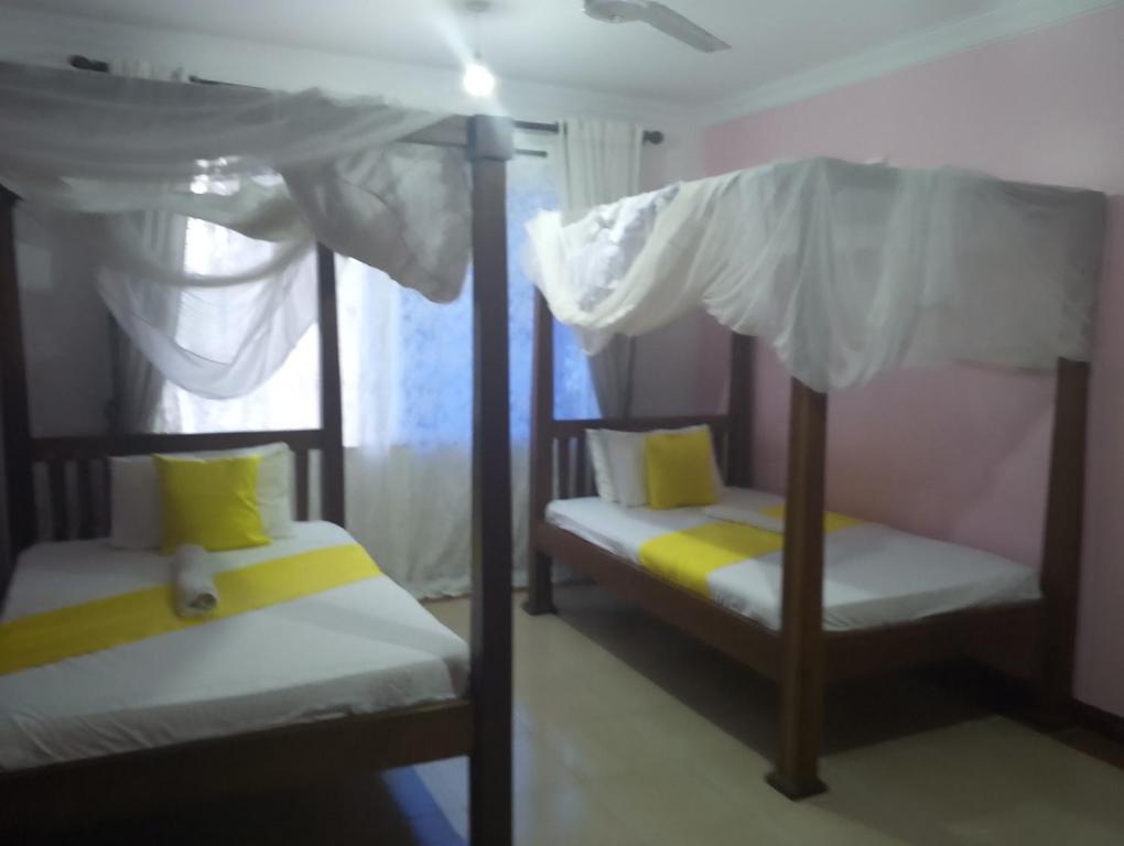 Un dormitorio con dos literas y una ventana. en Royal D8, en Mombasa