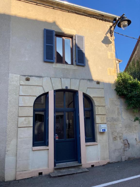 ein Gebäude mit einer blauen Tür und einem Fenster in der Unterkunft La petite Maison in Pougues-les-Eaux