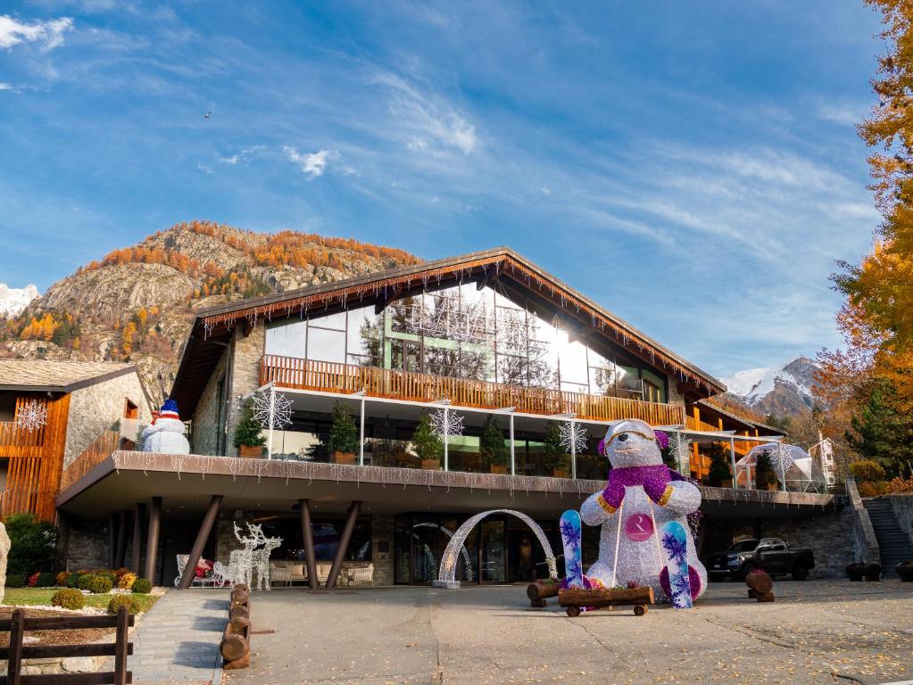 a large building with a teddy bear in front of it at Grand Hotel Courmayeur Mont Blanc, by R Collection Hotels in Courmayeur