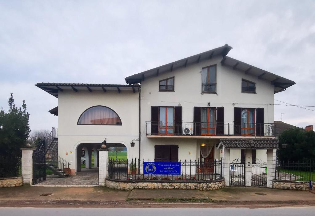 a white house with a balcony and a gate at Paradise B&B in Panicarola