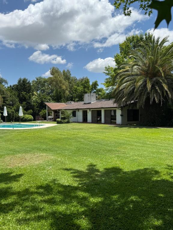 una casa con una palma di fronte a un cortile di LPR EZE Airport a La Unión