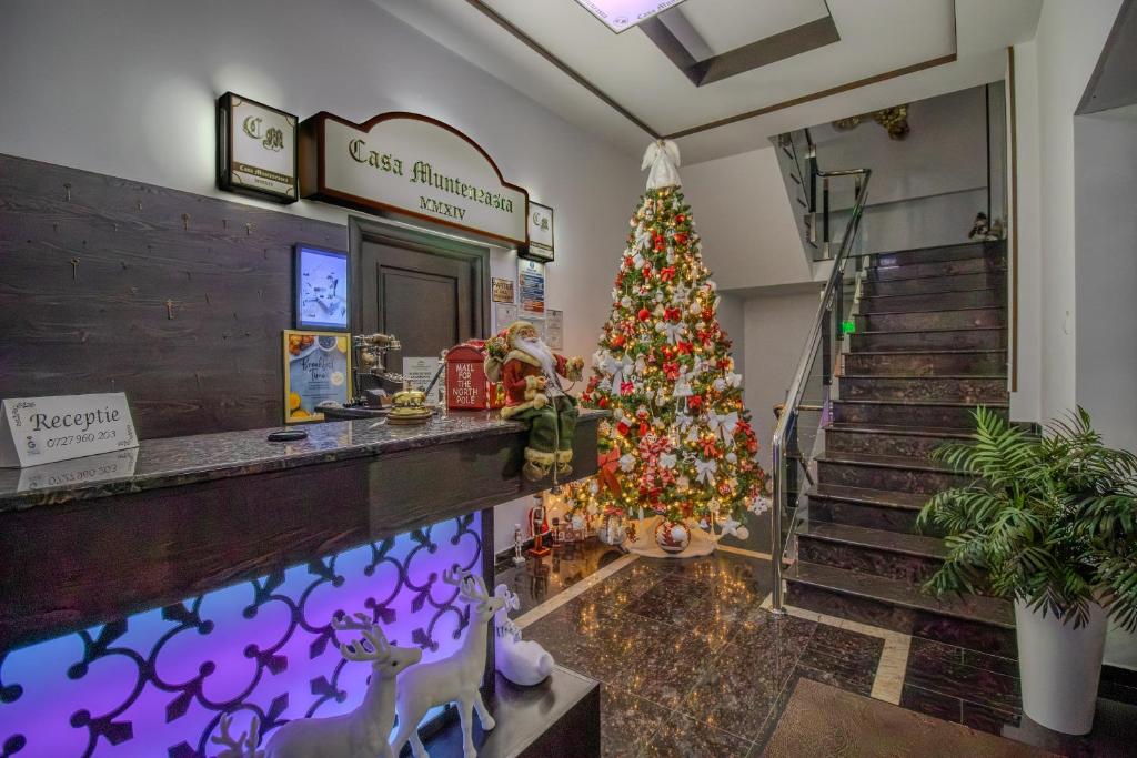 Un árbol de Navidad en la entrada de una tienda. en Hotel Casa Muntenească Alessandro, en Piteşti