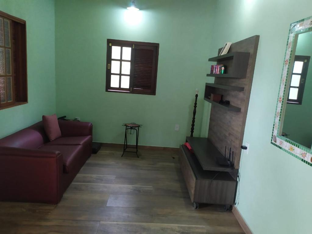 ein Wohnzimmer mit Sofa und Kamin in der Unterkunft Quintal dos Pinheiros in Pirenópolis