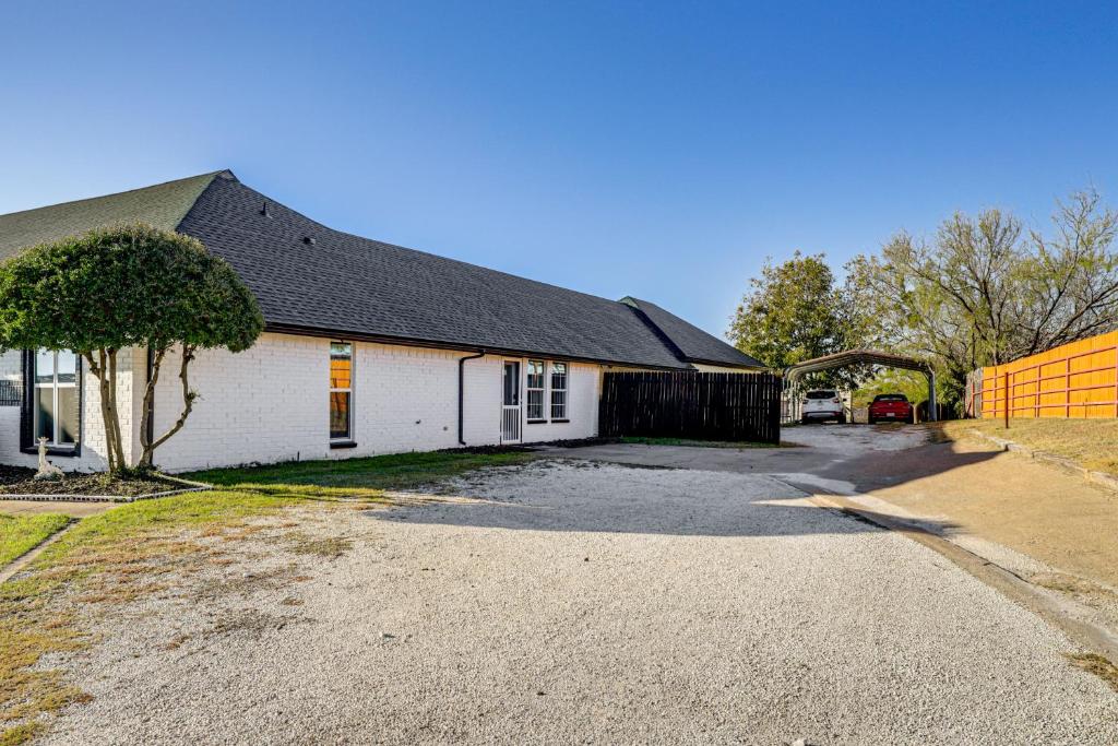 ein weißes Haus mit einem schwarzen Dach und einer Auffahrt in der Unterkunft Granbury Studio - 10 Mins From Town and The Lake! in Granbury