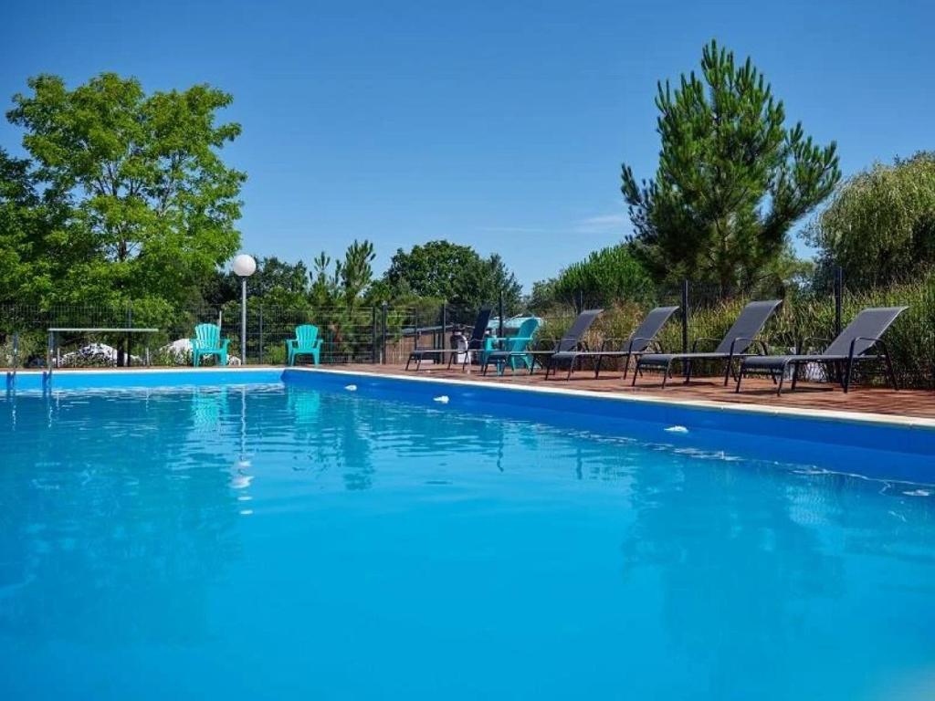einen großen Pool mit blauem Wasser und Stühlen in der Unterkunft Camping 4 étoiles - Parc aquatique - ccbcbhg in Caro