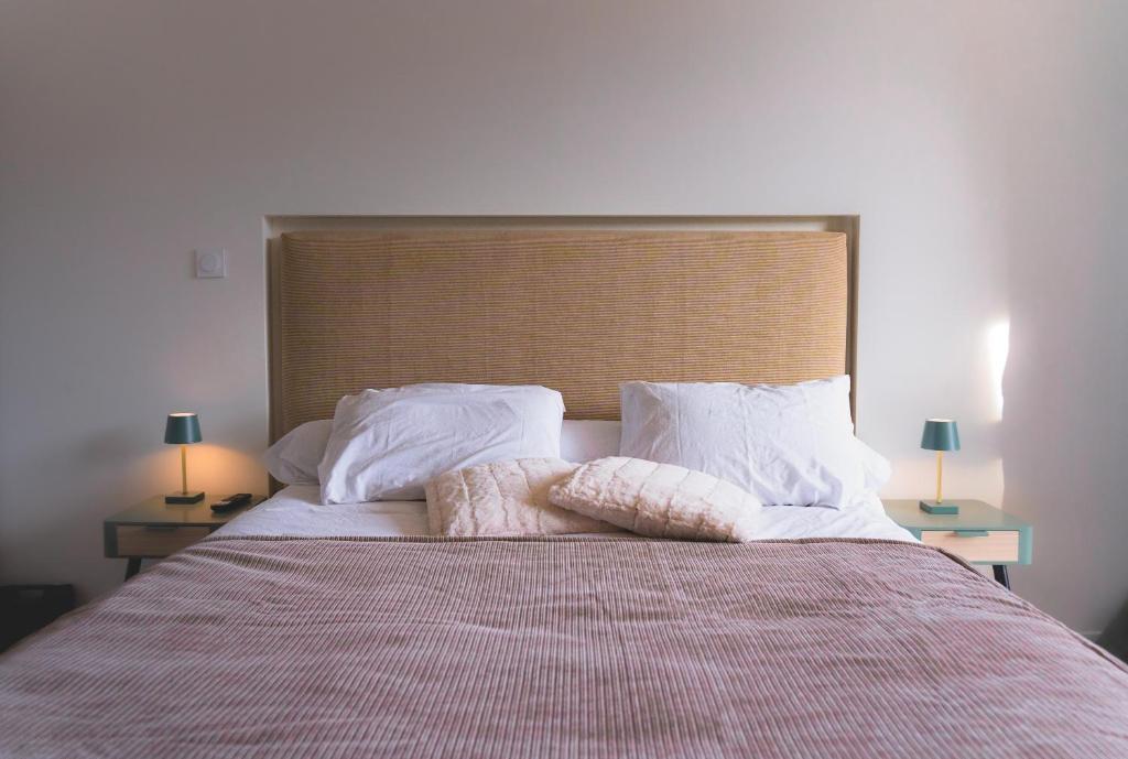 een slaapkamer met een bed met twee kussens en twee lampen bij Kj Homes in Prénatier