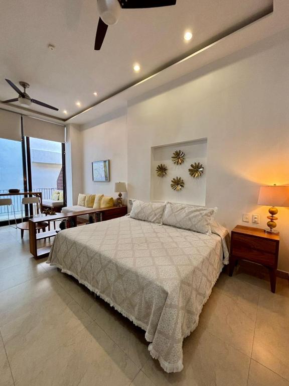a bedroom with a bed and a living room at Penthouse Studio 2 blocks from Los Muertos beach in Puerto Vallarta