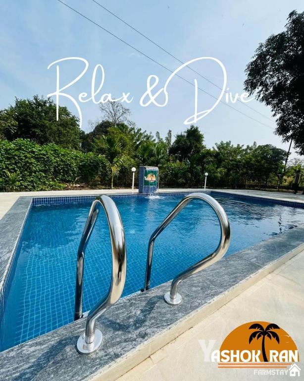 una piscina con dos pasamanos de metal al lado en Yashokiran Farmstay, en Borlai